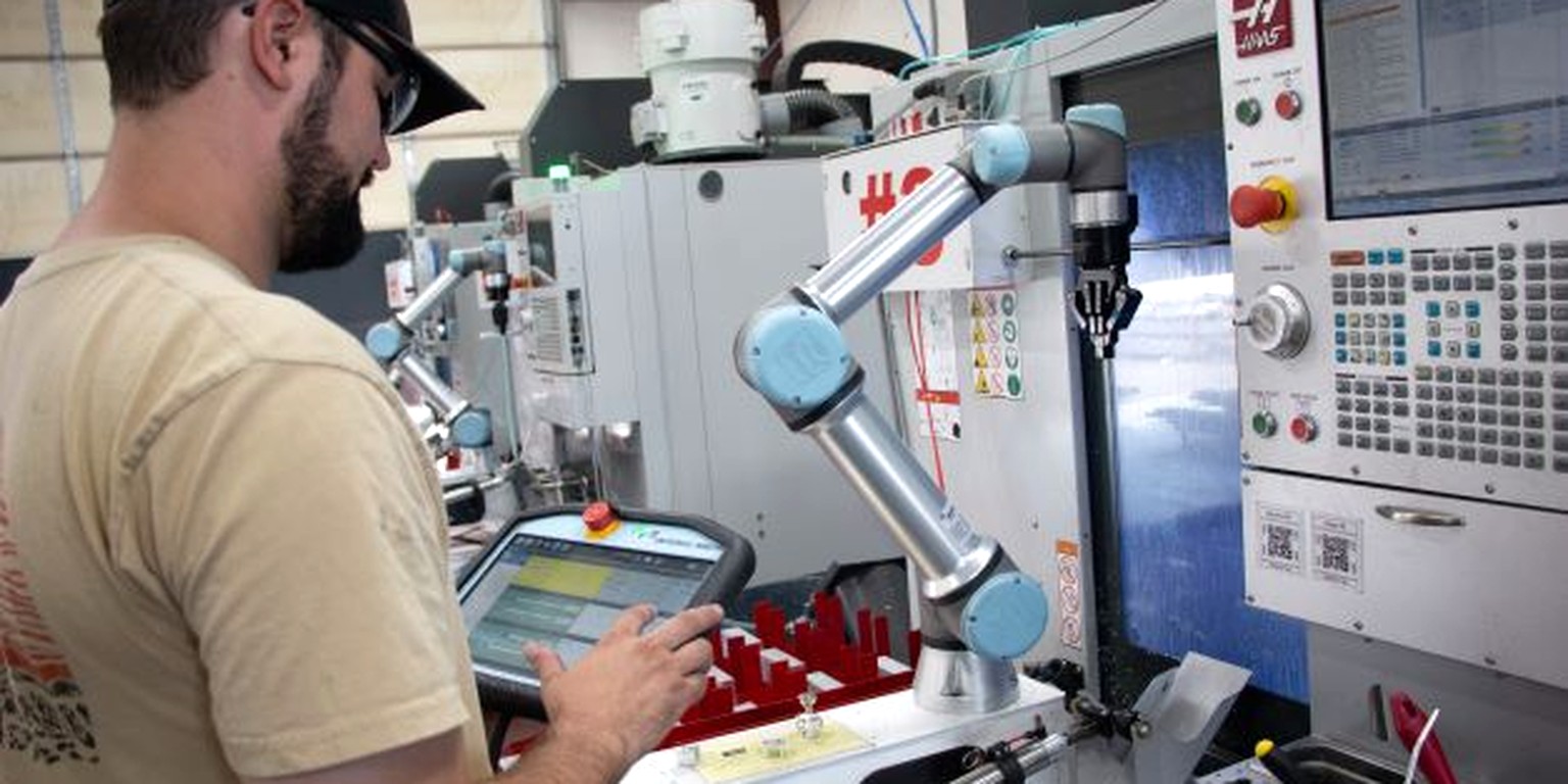 Robotic cell tending two CNC machines in a bright factory